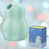 A sleek, mint-colored Satisfyer Pro To Go 1 Air Pulse Clitoral Stimulator is set against a softly blurred background accented by pastel lighting. Beside the device sits its blue and yellow packaging, showcasing an illustration of the product tailored for clitoral stimulation.